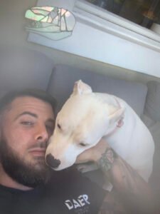 man and white pit bull